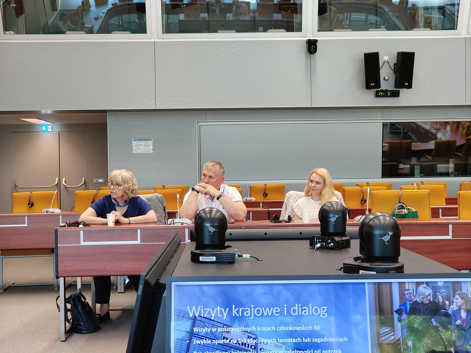 The photo shows three people sitting at a table